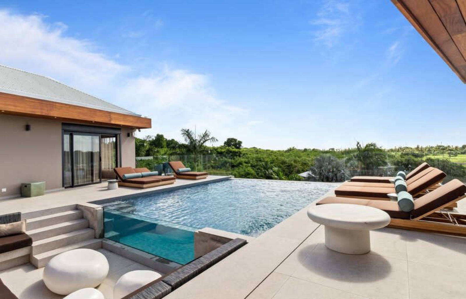 Villa Hemera — piscine et terrasse avec transats face à la végétation tropicale à Saint-François